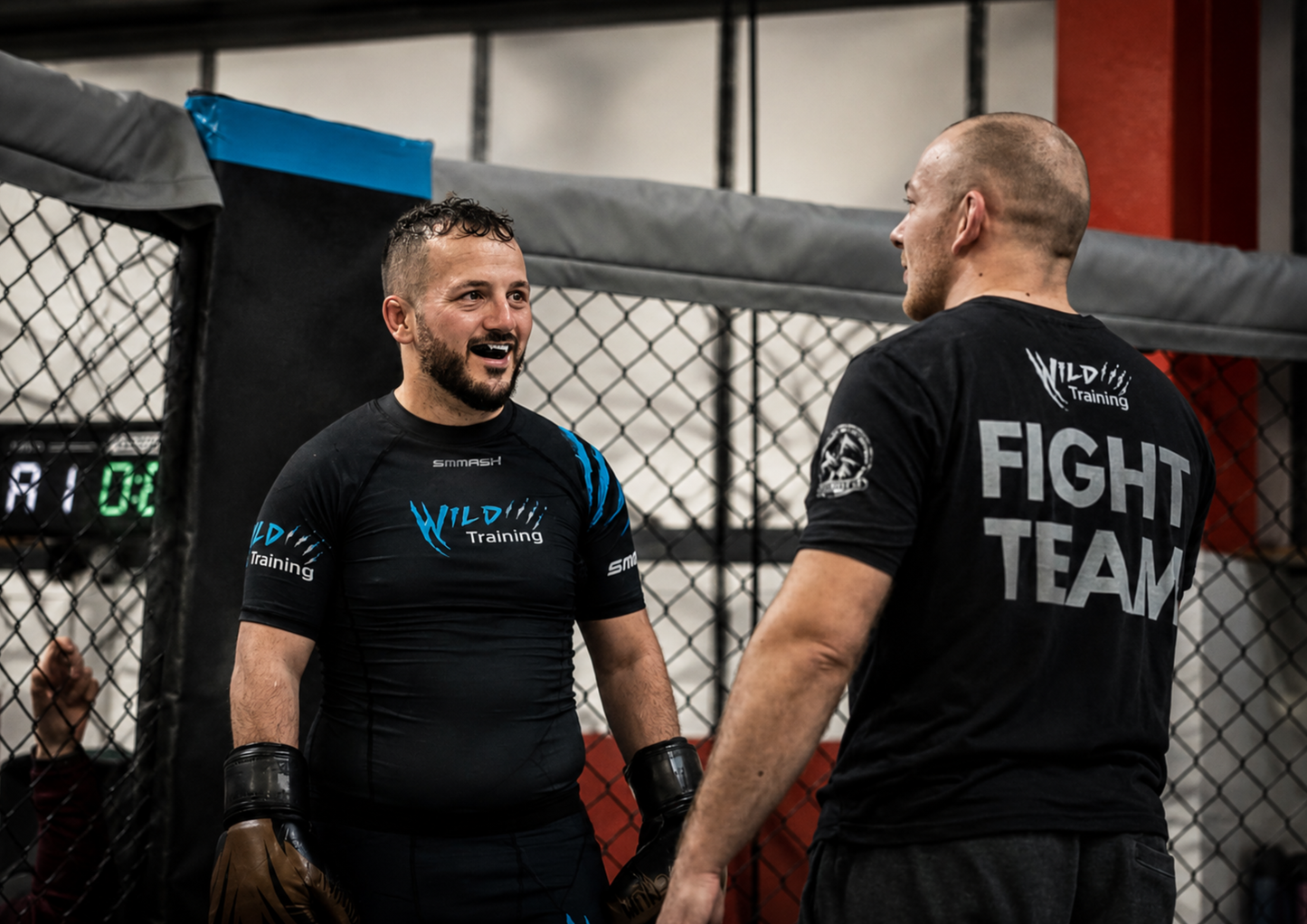 Two athletes stand inside a training facility wearing matching branded team apparel. The image highlights team pride, identity and the role of quality branded clothing in creating a sense of belonging.