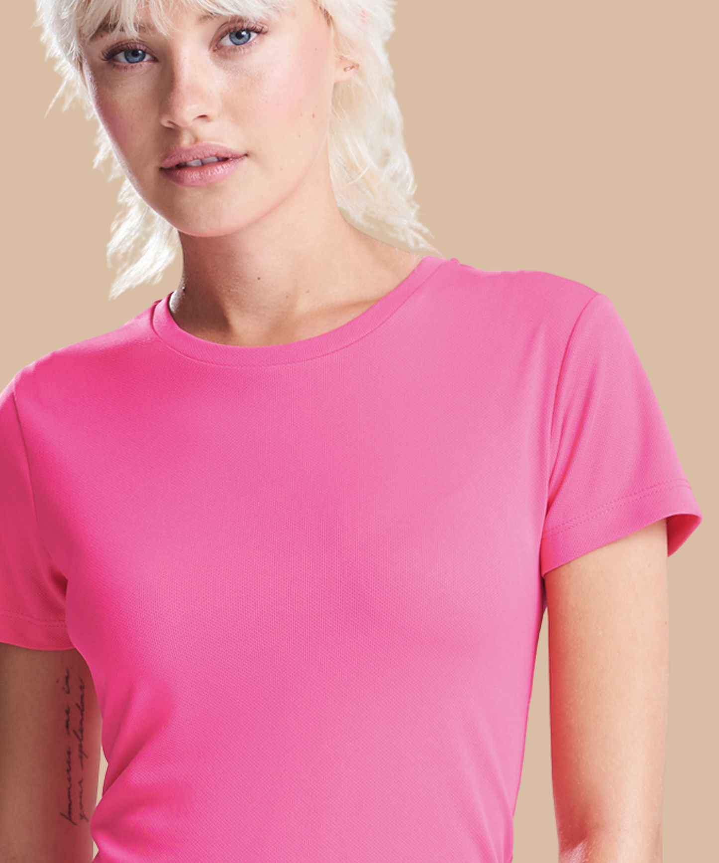 Person wearing a bright pink t-shirt against a beige background. Standard stock for Pathfinder Printworks hand printing services. Based in South Wales.