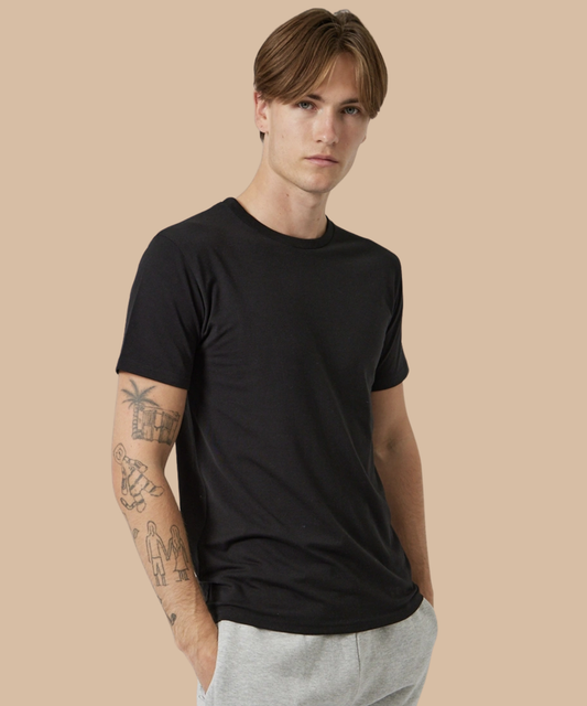 Man wearing a black t-shirt against a beige background. Standard stock for Pathfinder Printworks hand printing services. Based in South Wales.