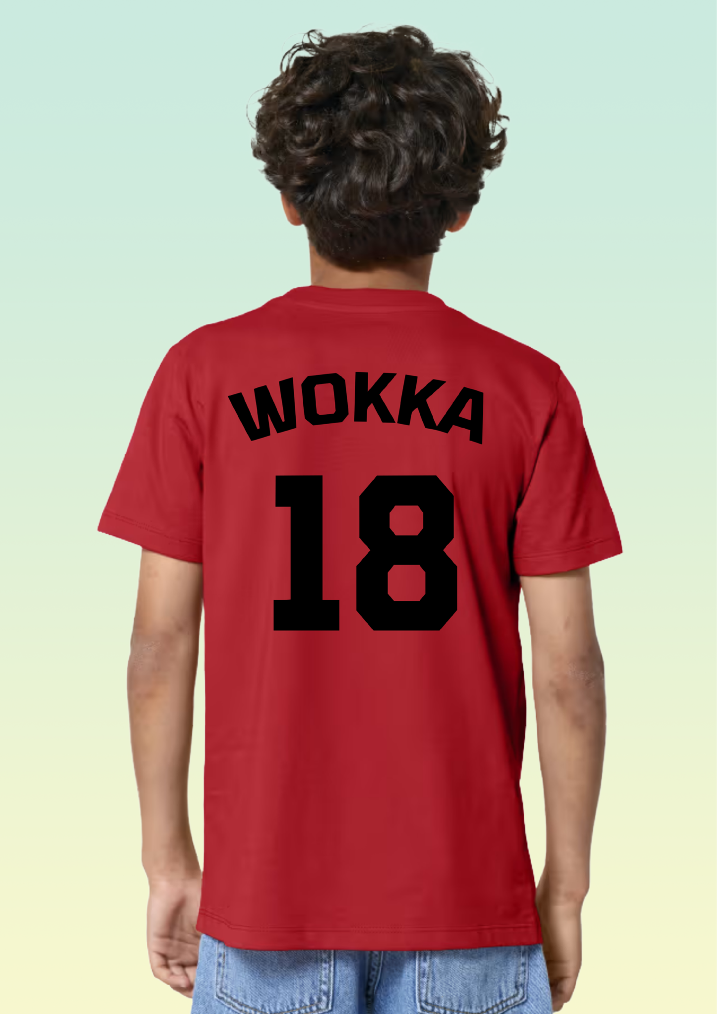 A child shown from the back wearing a bright yellow short-sleeve T-shirt with green text reading 'WOKKA' and the number '18' on the back, paired with blue jeans against a pale gradient background. Exclusive to Flying Teez.