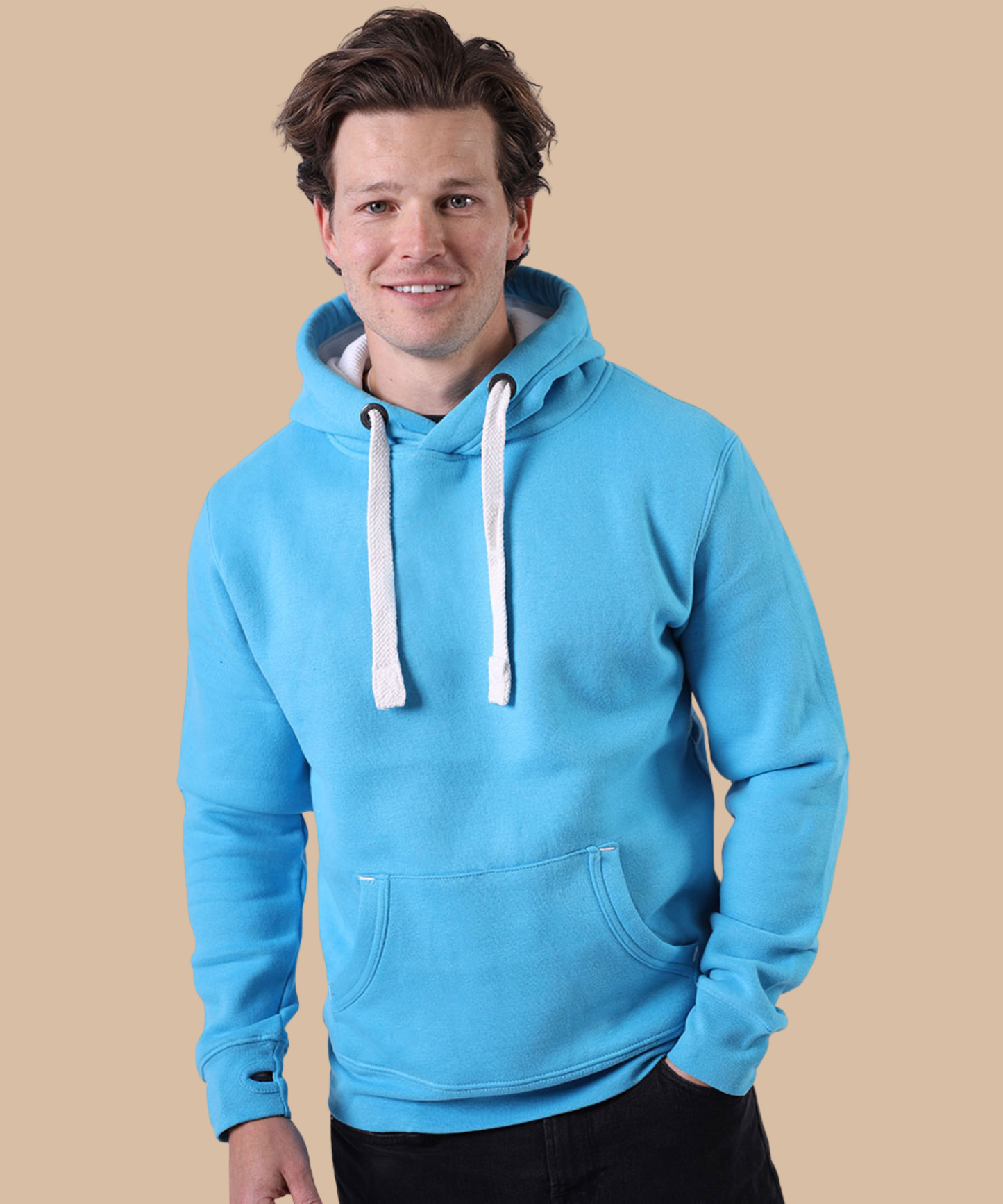 A man wearing a bright blue pullover hoodie with white drawstrings, adjusting the hood against a solid beige background. Pathfinder Printworks hand print apparel for clubs, teams and businesses.