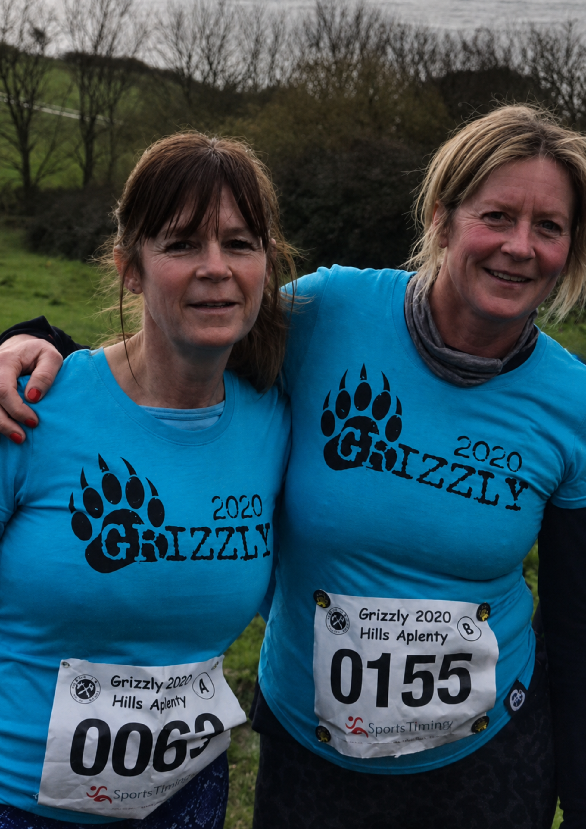 A group of runners wearing matching team shirts, smiling and chatting as they take part in an organised event. The image highlights friendship, community and the shared identity created through team apparel.