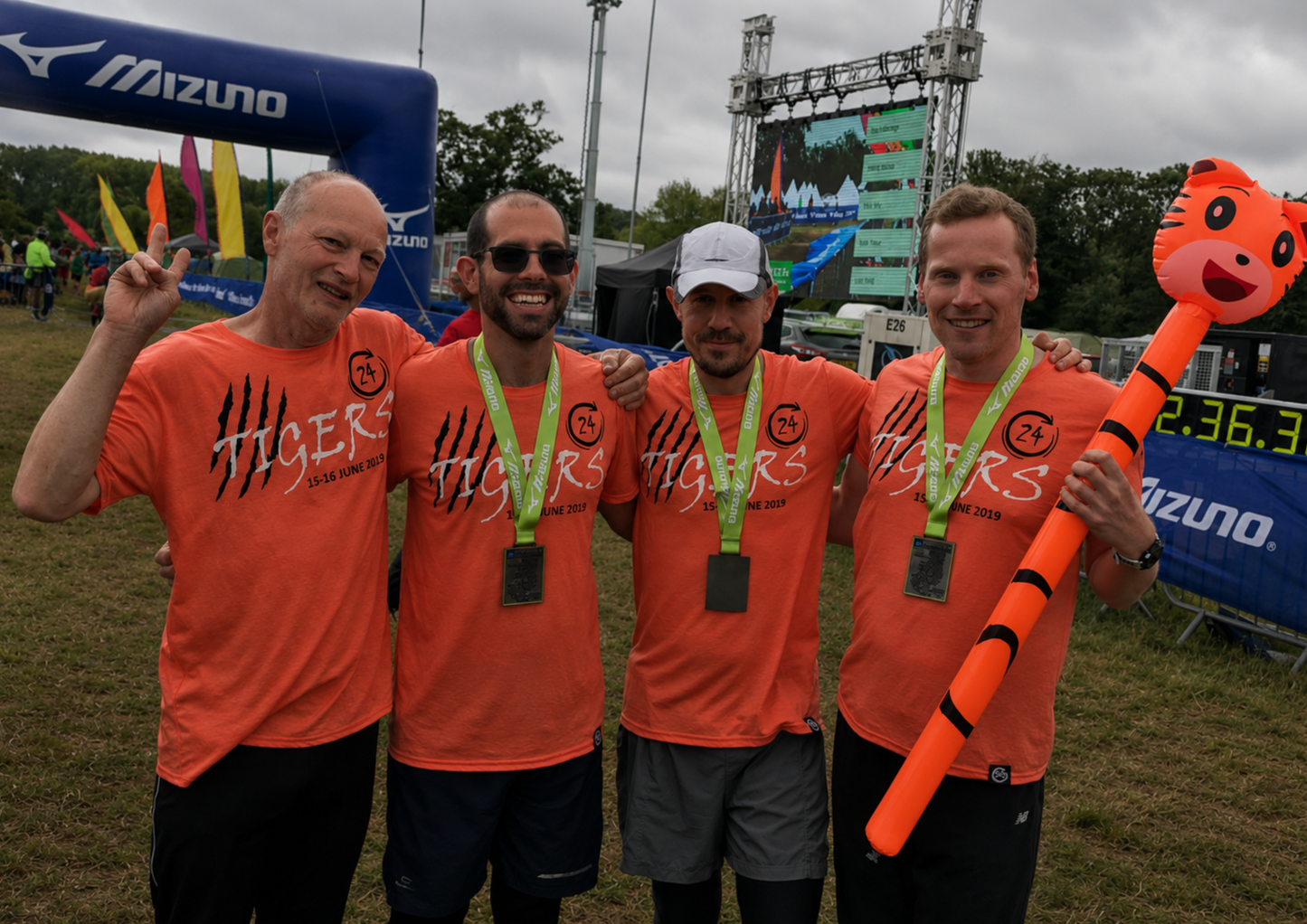 Four team members stand together after completing an event, wearing matching branded shirts and medals. The image captures friendship, shared achievement and the pride that comes from accomplishing something together.