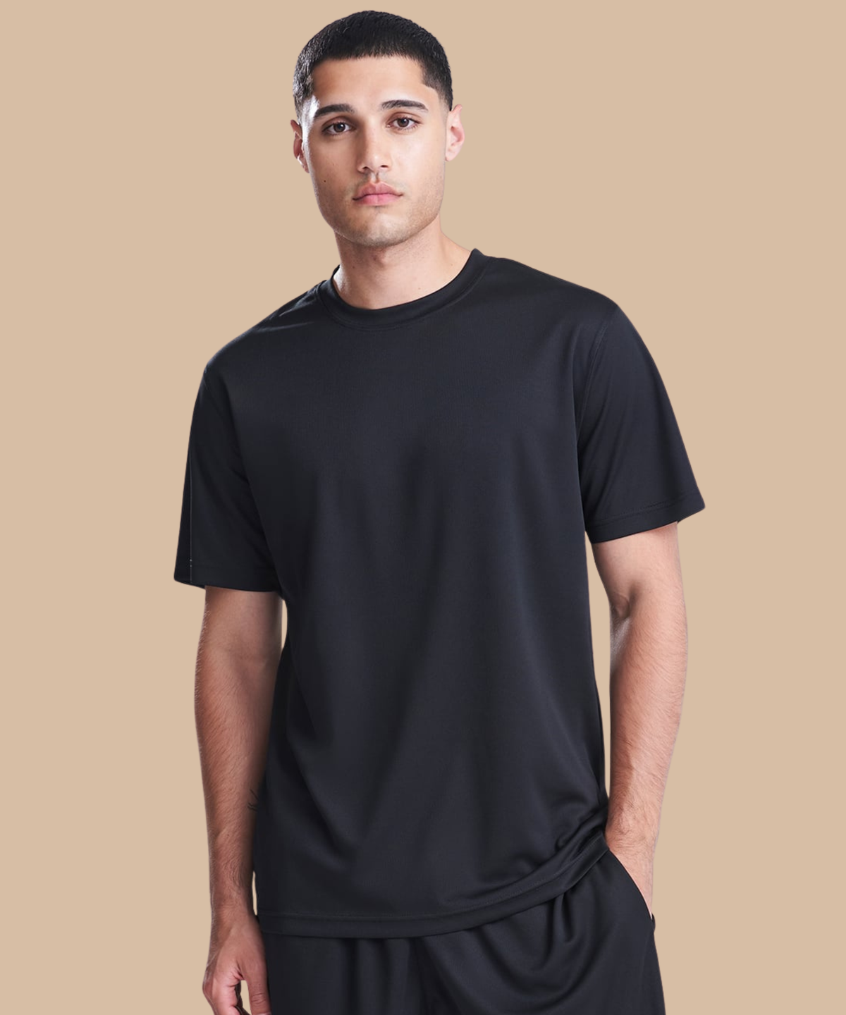 Man wearing a black t-shirt against a beige background. Standard stock for Pathfinder Printworks hand printing services. Based in South Wales.
