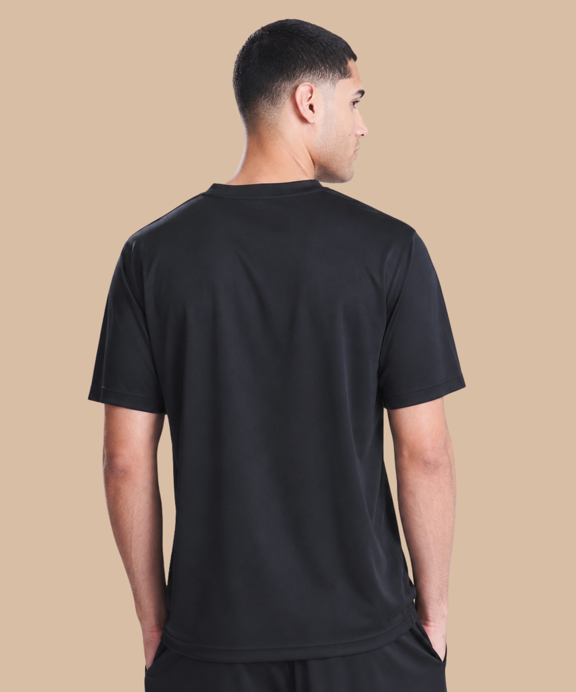 Man wearing a black t-shirt on a beige background. Standard stock for Pathfinder Printworks hand printing services. Based in South Wales.