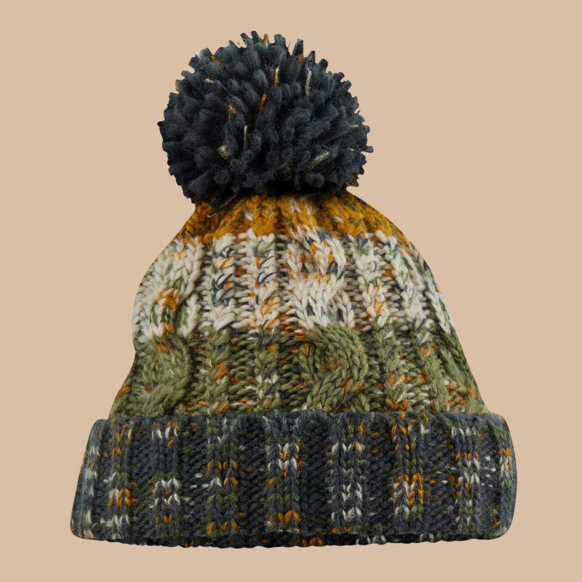 A multicolour knit pom-pom beanie hat featuring a dark navy blue pom-pom, a dark navy ribbed cuff, and a body with textured cable-knit patterns in olive green, cream, and mustard yellow, set against a solid beige background. Embroidery services from Pathfinder Printworks, based in South Wales.