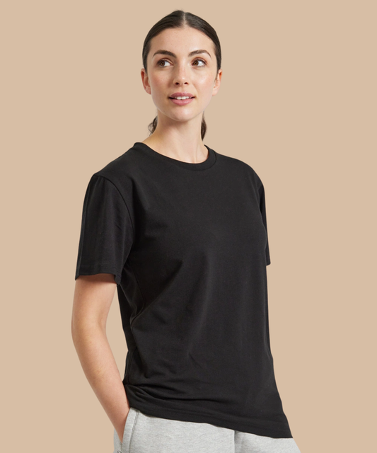 A woman modelling a plain black short-sleeve crewneck t-shirt against a solid beige background. Pathfinder Printworks offer printing services to clubs, teams and businesses.