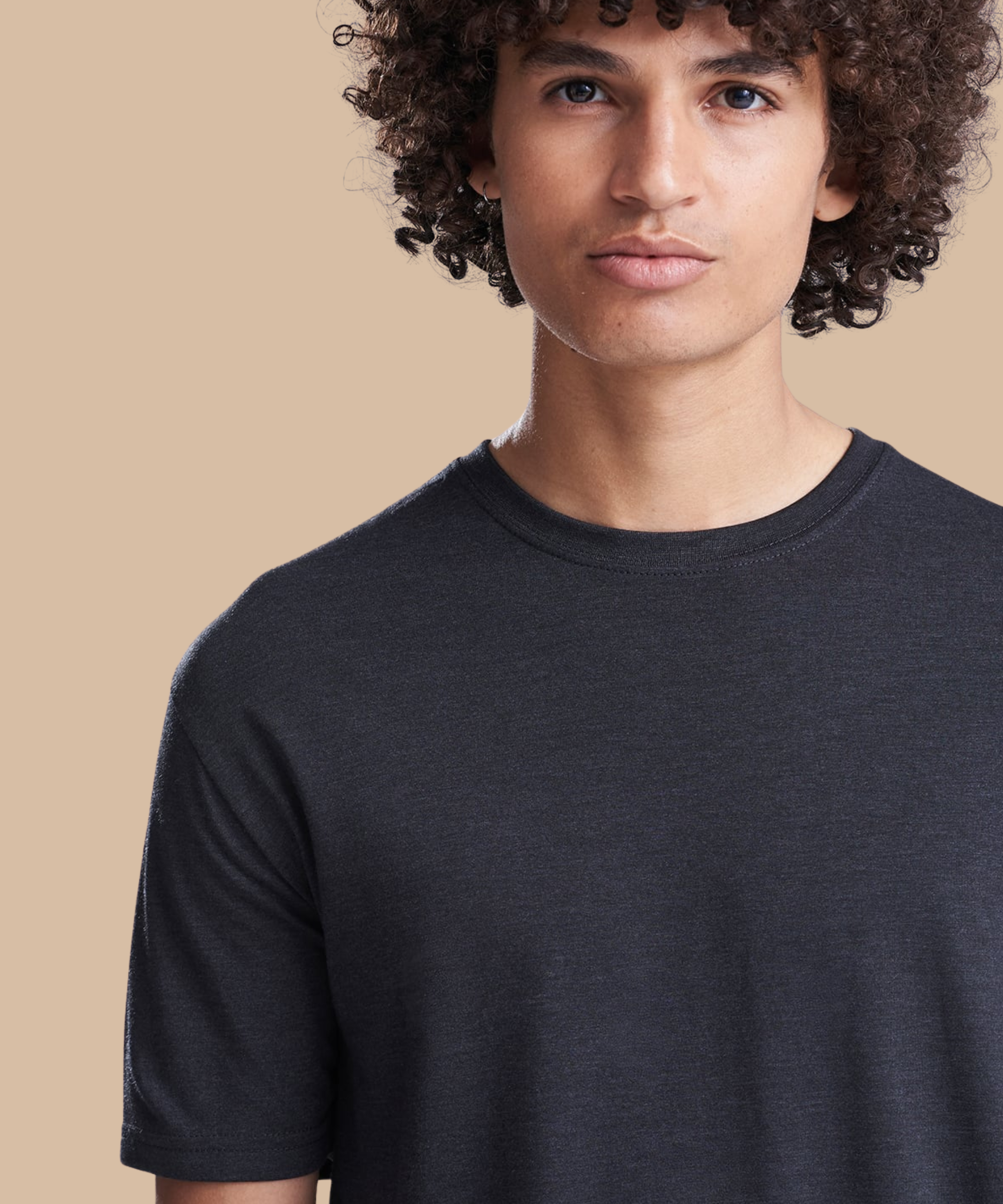 Person wearing a black t-shirt against a beige background. Standard stock for Pathfinder Printworks hand printing services. Based in South Wales.
