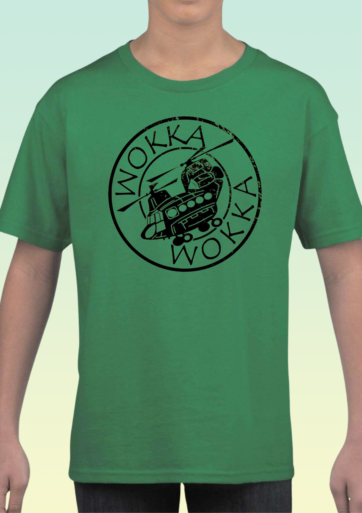 A green short-sleeve crewneck t-shirt featuring a black circular graphic with the word 'WOKKA' and a helicopter-themed illustration, worn by a model. Exclusive to Flying Teez.