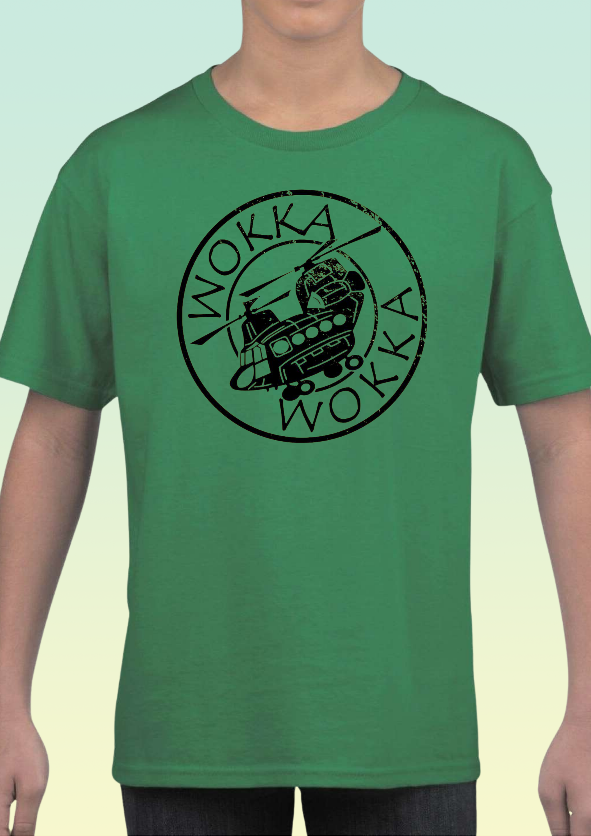 A green short-sleeve crewneck t-shirt featuring a black circular graphic with the word 'WOKKA' and a helicopter-themed illustration, worn by a model. Exclusive to Flying Teez.