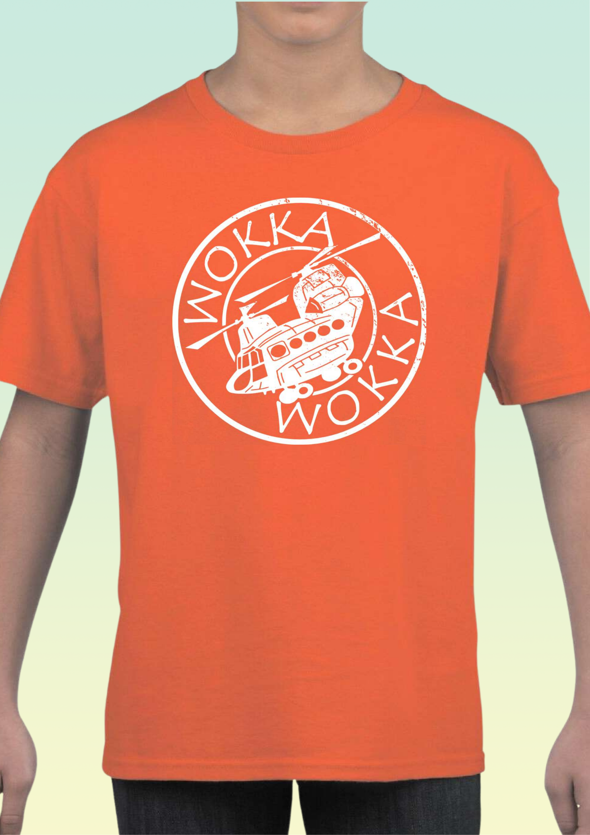 A child wearing a bright orange short-sleeve t-shirt with a white circular graphic on the chest featuring a helicopter logo and the word 'WOKKA' repeated. Exclusive to Flying Teez.