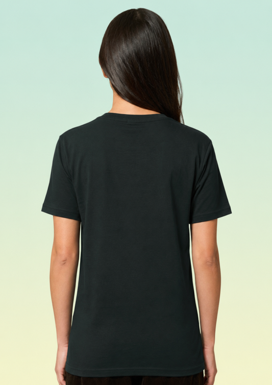 A woman viewed from the back wearing a plain black short-sleeve crewneck T-shirt, set against a light green to pale yellow gradient background.